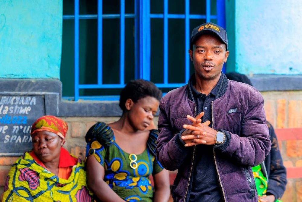 Design Fellow Alexis Mbarushimana engages with community members during a field discussion in Bucyaba Village, Gakenke District.