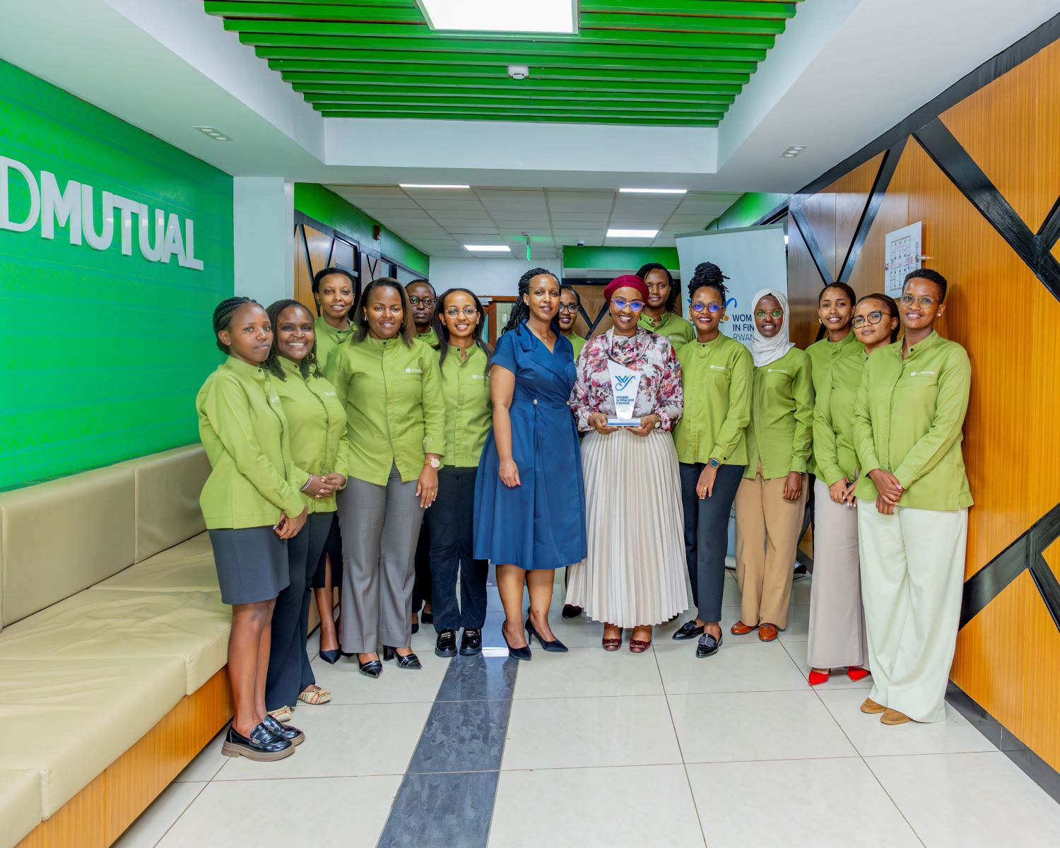 Old Mutual Insurance Rwanda staff pose for a photo with the company's Managing Director, Annie Nibishaka, and Betty Sayinzoga, Co-founder of WIFR.
