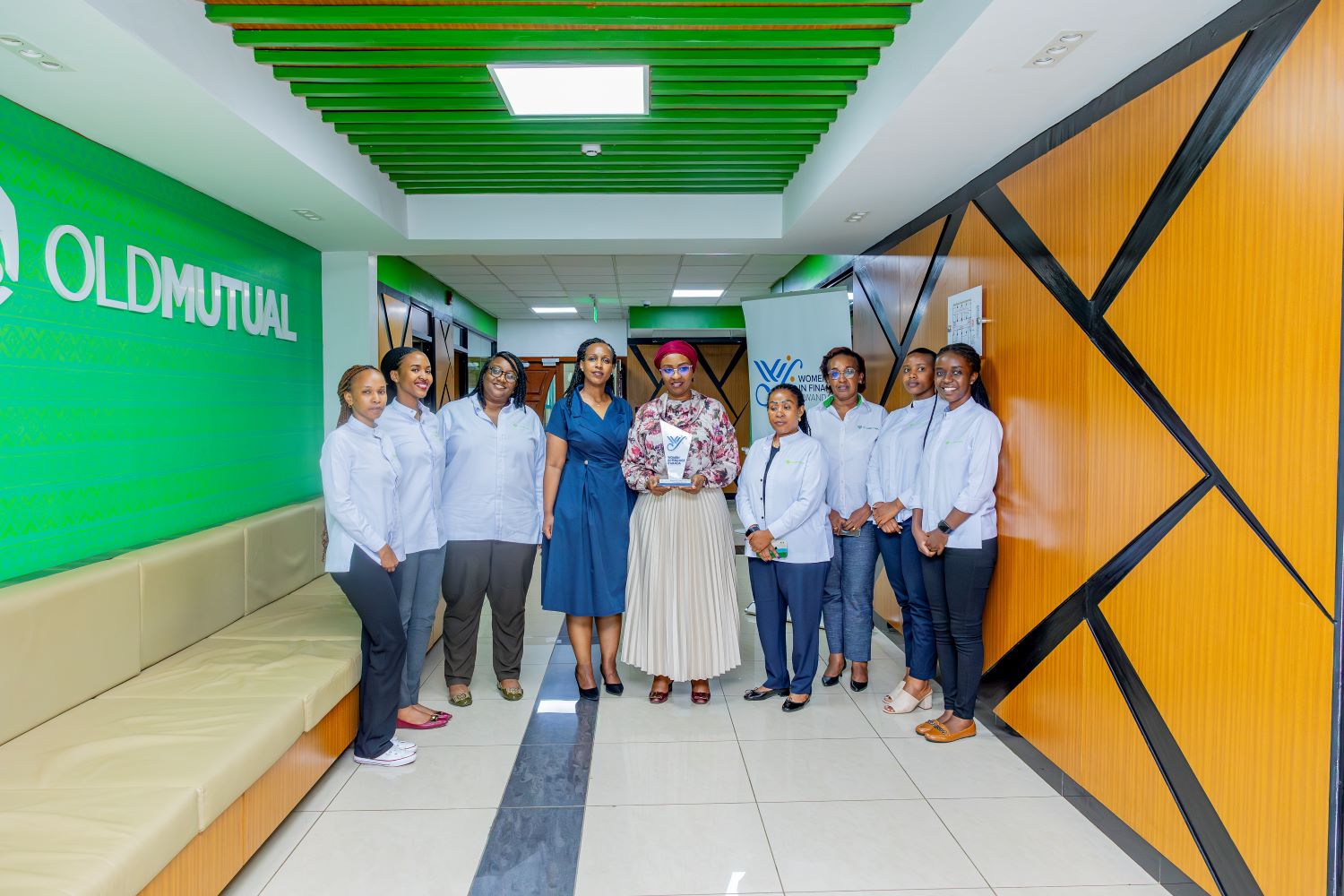 Old Mutual Insurance Rwanda staff pose for a photo with the company's Managing Director, Annie Nibishaka, and Betty Sayinzoga, Co-founder of WIFR.