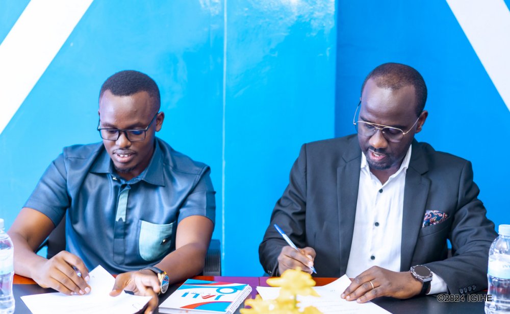 The CEO of Koi Pay, Frank Mugisha (left) and the CEO of Jali Finance, Felix Nkundimana signing acquisition agreements.