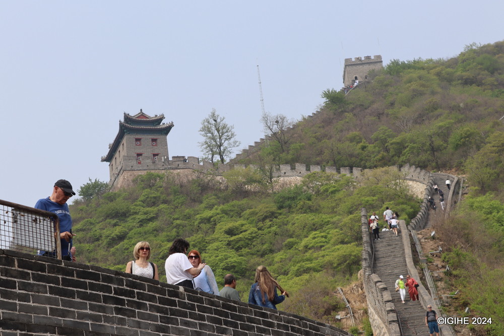 Some visitors take a moment to rest midway through their hike up the Great Wall before continuing their journey.