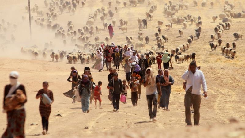 Displaced people from the Yazidi sect flee ISIL towards the Syrian border in August 2014