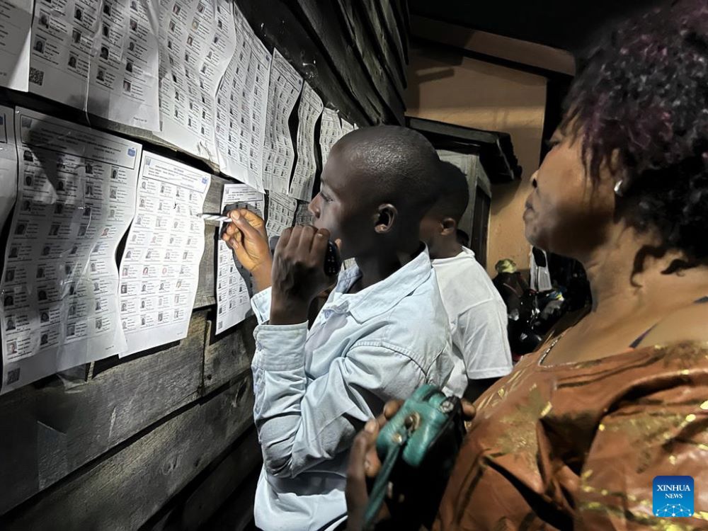 Voters check information outside a polling station in Goma, capital of North Kivu province, eastern Democratic Republic of the Congo (DRC), on Dec. 20, 2023. Polling for the general elections will continue on Thursday in the Democratic Republic of the Congo (DRC), announced Denis Kadima, president of the Independent National Electoral Commission (CENI), Wednesday evening. (Str/Xinhua)