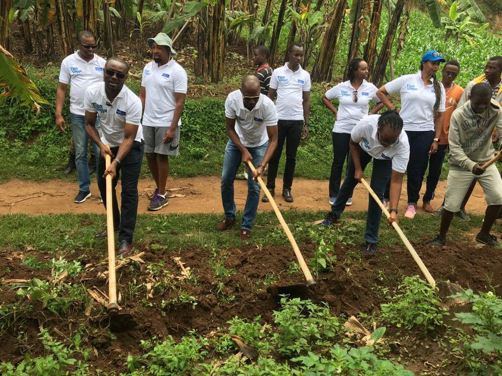 Tigo Rwanda staff and residents of Kayenzi, Burera District digging trenches for water pipes during the Community Work (Umuganda)