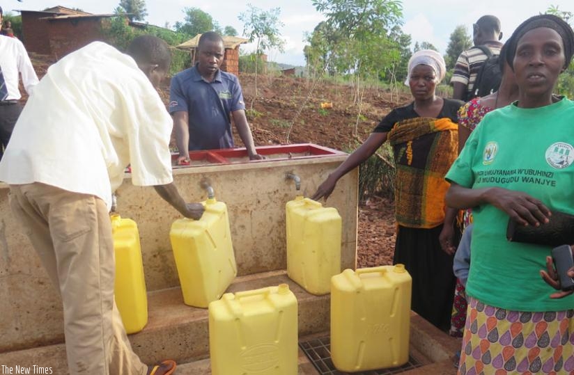 People fetch water from a public tap in Bitoma I village. The water supply system was built with the support of Japan International Cooperation Agency. Photo The New Times.