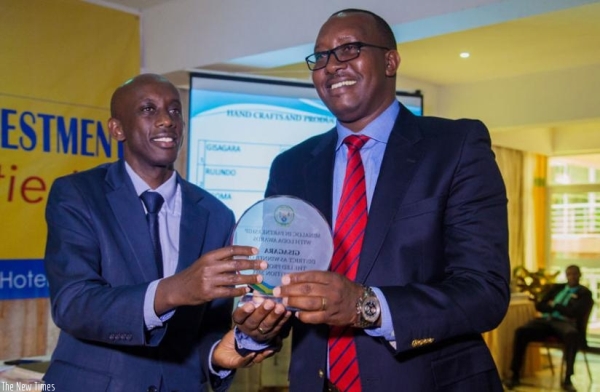 Kaboneka (L) hands over the winner's award to Gisagara mayor Leandre Karekezi.
