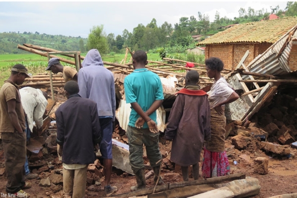 Residents of Mbazi Sector near Rwabuye marshland assess the damage caused by last week’s downpour.
