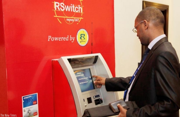 A bank customer withdraws money using his ATM card 