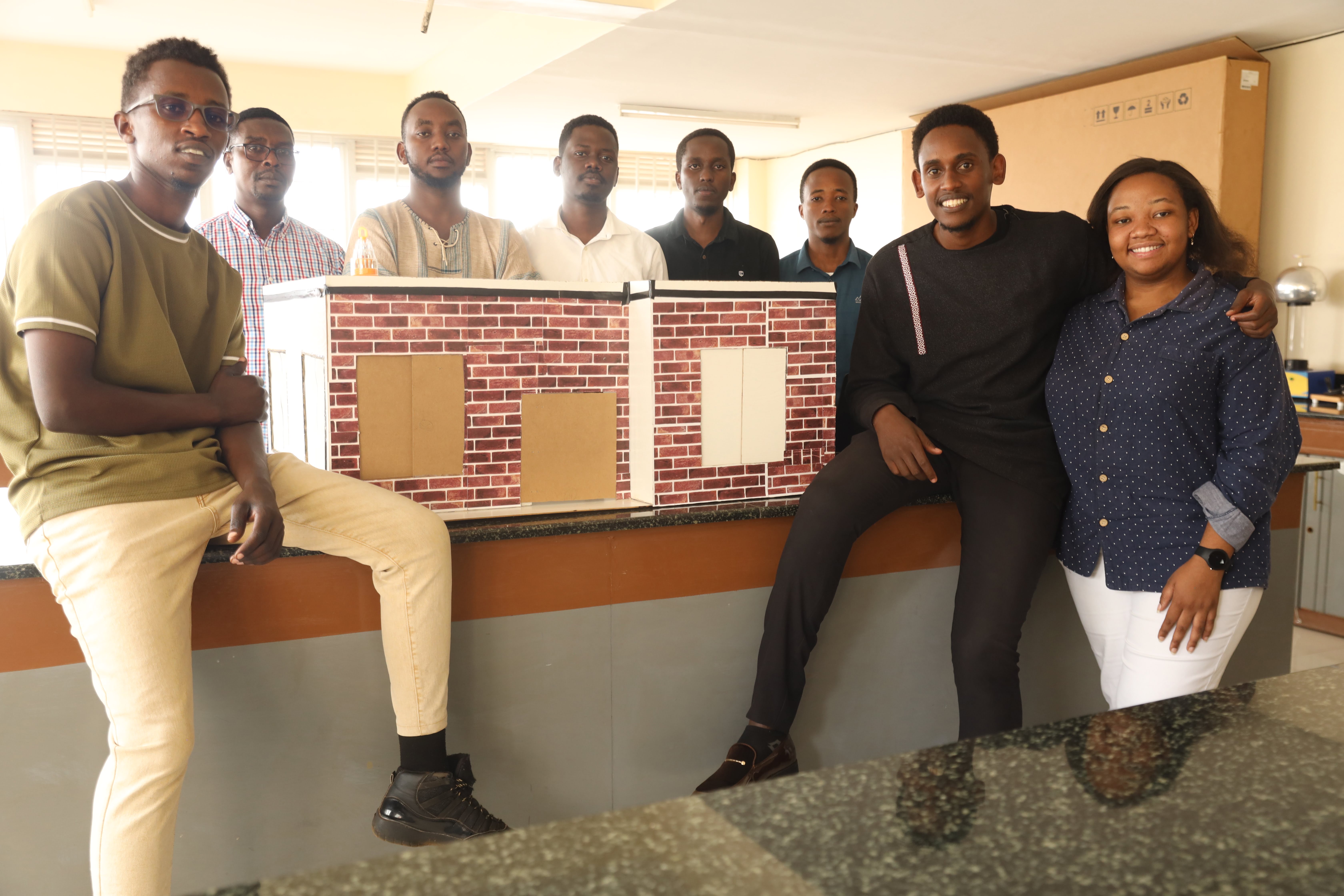 The students and their lecturer pose for a photo next to the model house used for demonstration of their 'Smart Homes' system.