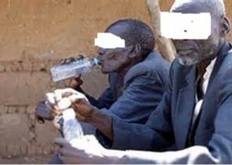 Old men drinking illicit brews