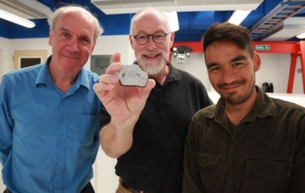 This image shows from left Paul Warren, Edward Young and Issaku Kohl. Young is holding a sample of a rock from the moon.