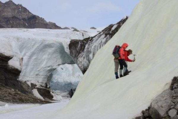 Associate Professor Alexis Templeton and Dr. Stephen Grasby prospecting for sulfur biominerals in a yellow sulfur deposit forming on a glacier surface in the High Arctic.