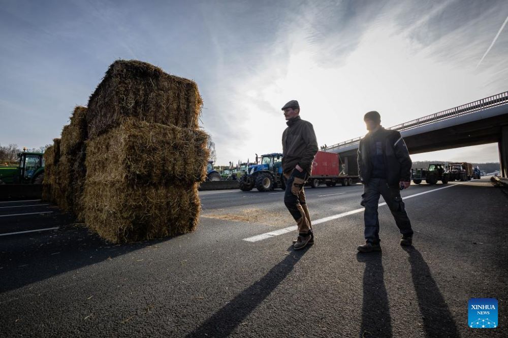 French farmers block a highway with their tractors during a protest in Longvilliers, near Paris, France, on Jan. 29, 2024. French farmers blocked motorways around Paris on Monday afternoon as they continued protesting against rising prices, red tape and "unfair competition" from other countries. (Photo by Aurelien Morissard/Xinhua)