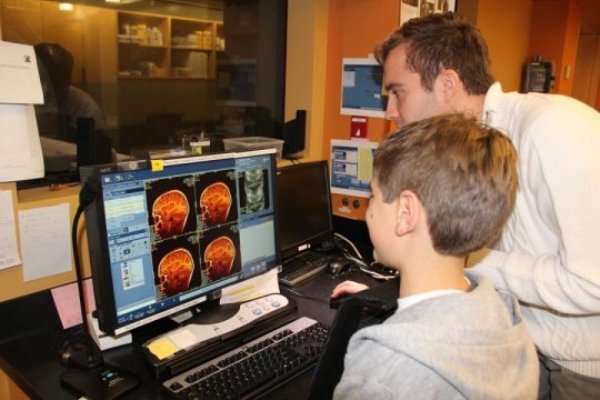 Researcher shows the child images of his brain just taken on the MRI machine. This material relates to a paper that appeared in the Jan. 6, 2017, issue of Science, published by AAAS. The paper, by J. Gomez at Stanford University School of Medicine in Stanford, Calif., and colleagues was titled, "Microstructural proliferation in human cortex is coupled with the development of face processing."