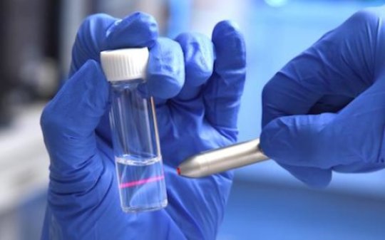 Laser light can be seen scattered by nanoparticles in a solution of the UTSW-developed nanovaccine.