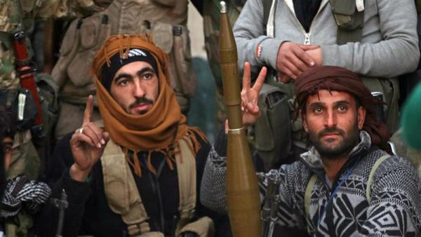 Rebel fighters pose in an opposition-held area of Aleppo on Thursday