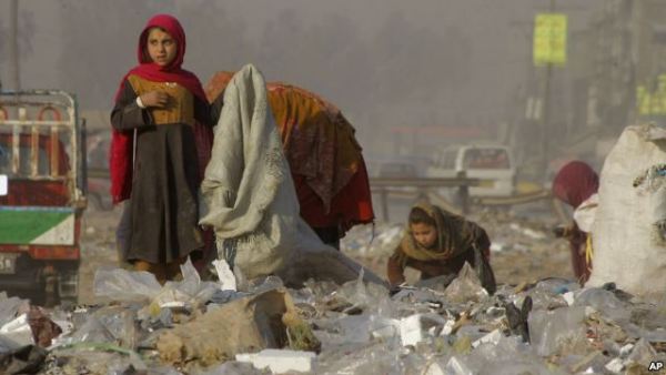 Afghan refugees girls collect recycle-able goods from a garbage to sell and earn living for their families in Peshawar, Pakistan, Feb. 5, 2016.