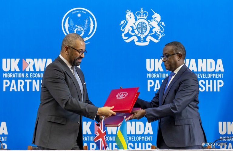 The Minister of Foreign Affairs, Dr. Vincent Biruta exchanging documents with UK Home Secretary, James Cleverly after signing the revised migration treaty in Kigali.