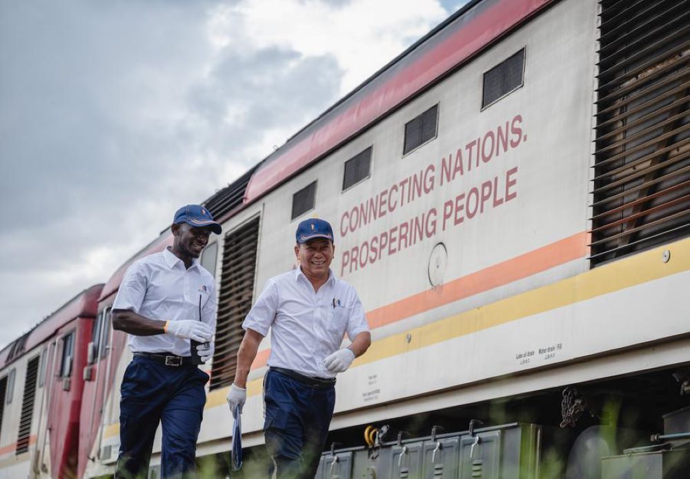 Chinese instructor Jiang Liping (R) and apprentice Horace Owiti walk past a train carriage on the Mombasa-Nairobi Railway in Nairobi, Kenya, May 23, 2023. (Xinhua/Wang Guansen)