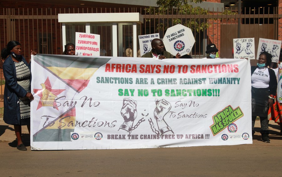 Members of the Broad Alliance Against Sanctions hold anti-sanctions placards in front of the U.S. embassy in Harare, Zimbabwe, on July 4, 2022. (Photo by Tafara Mugwara/Xinhua)