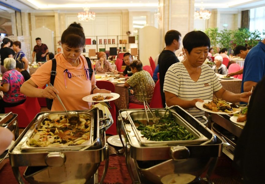 Villagers of Qinglonghu Town have meal at a temporary shelter after being evacuated from flood-hit areas in Fangshan District, Beijing, Aug. 1, 2023. (Xinhua/Zhang Chenlin)
