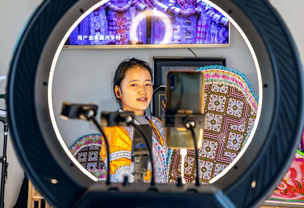 A villager promotes local products via livestreaming at the relocation site for poverty-stricken people in Huawu Village, Qianxi County of Bijie City, southwest China's Guizhou Province, April 13, 2021. (Photo by Fan Hui/Xinhua)