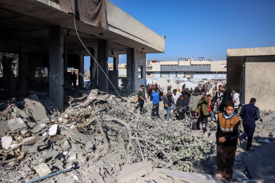 People gather at a building destroyed in an Israeli bombing in the center of the southern Gaza Strip city of Khan Younis, on January 2, 2025.