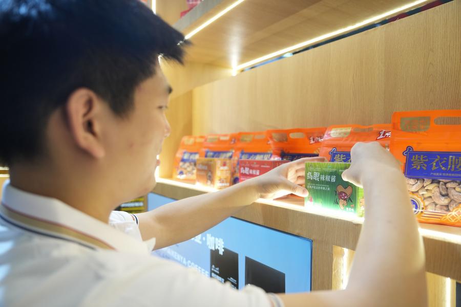 A volunteer arranges Rwandan chili sauce products during the 4th China-Africa Economic and Trade Expo in Changsha, central China's Hunan Province on June 12, 2025.