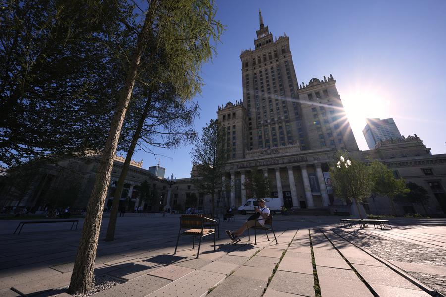 A man sits at a square next to the Palace of Culture and Science in Warsaw, Poland, on July 1, 2025. Poland's meteorological authorities have issued heat warnings for much of the country this week. 