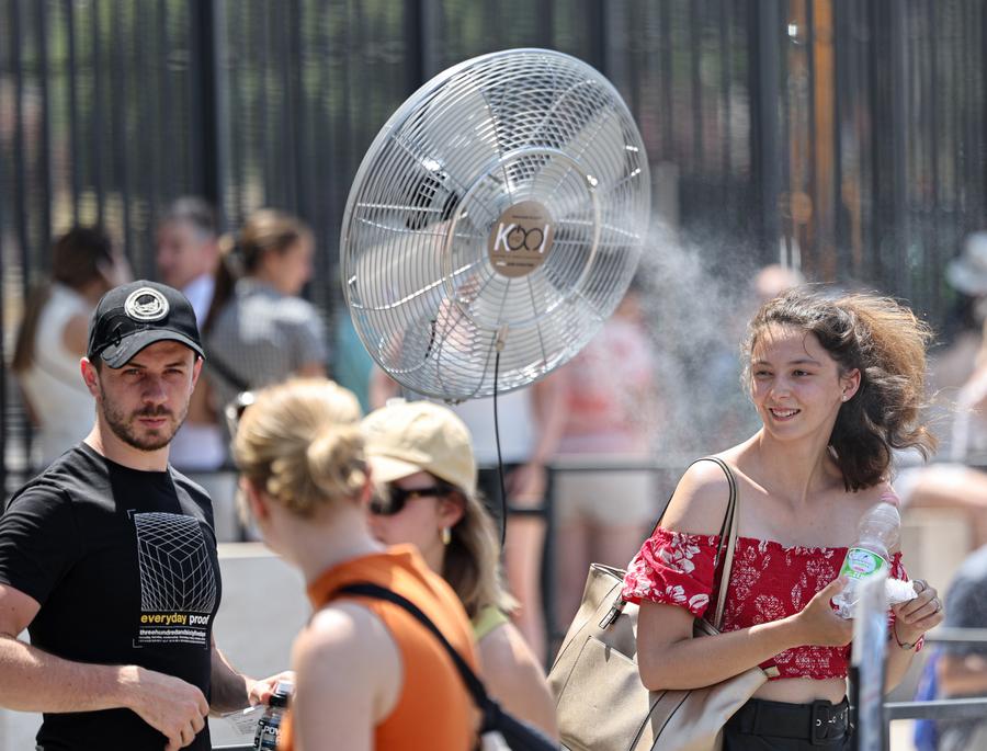 Tourists cool off in front of a fan near the Colosseum in Rome, Italy, June 27, 2025. Italy's Health Ministry has issued consecutive red alert heat warnings for dozens of major cities across the country, beginning June 27 and continuing through the weekend.