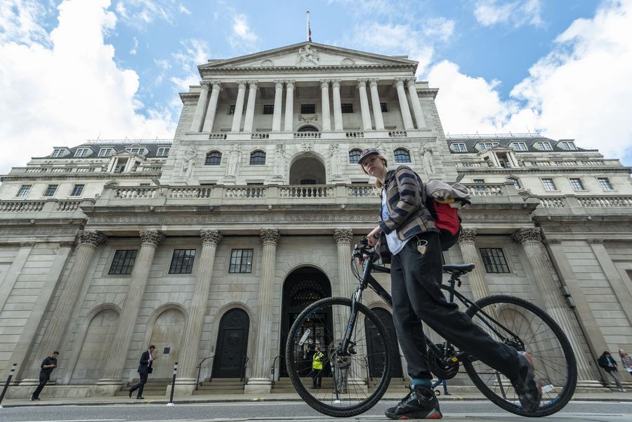 A woman walks past the Bank of England in London, Britain, on April 13, 2022. 
