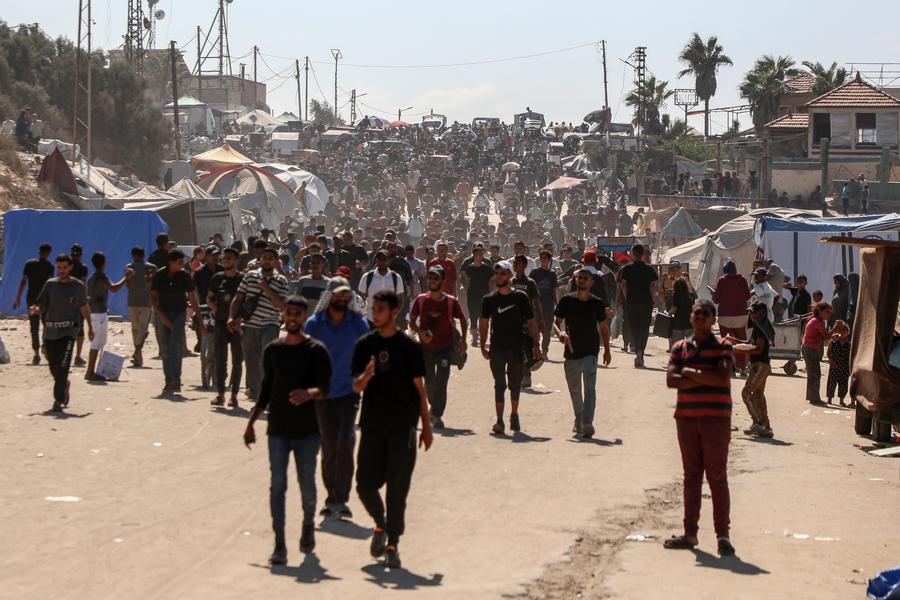 Palestinians walk on road returning to Gaza City, near the central Gaza Strip, October 10, 2025.