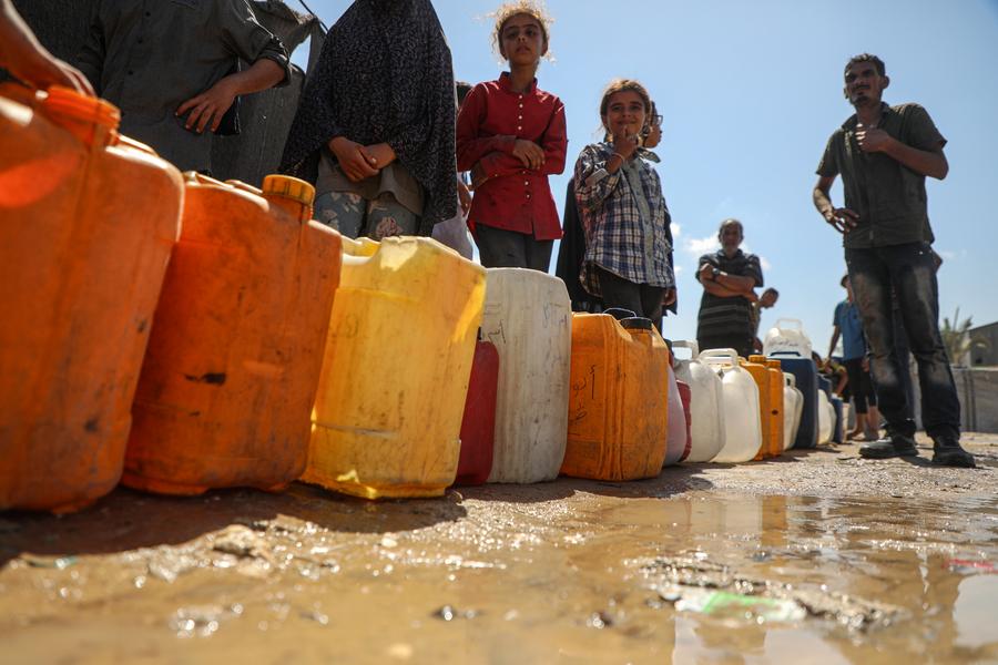 Displaced Palestinian children are seen fetching water at a temporary shelter in Deir al-Balah, in central Gaza Strip, September 23, 2025.