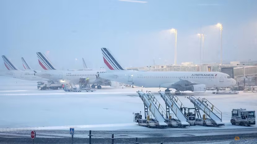 A view of Air France planes on the snow-covered tarmac at Terminal 2F of Paris' Charles de Gaulle Airport, as winter weather with snow and cold temperatures hit a part of France, on January 7, 2026.