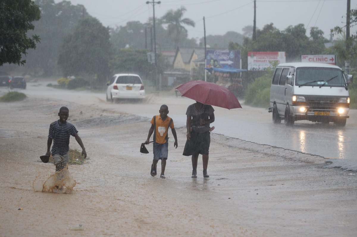 People walk in heavy rain in Harare, Zimbabwe, Jan. 24, 2026.