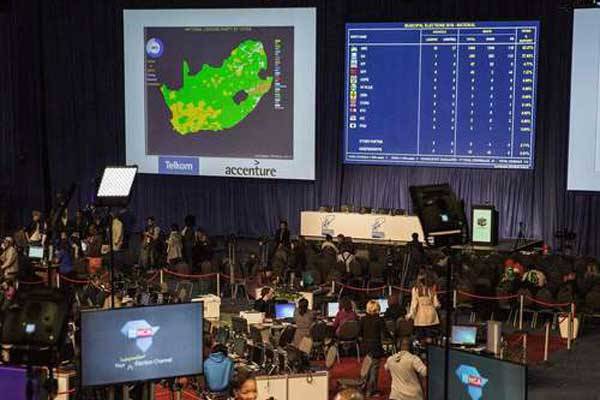 Media personnel, Independent Electoral Commission clerks and officers roam around the floor of the Independent Electoral Commission Counting centre on August 4, 2016 in Pretoria. Results from South Africa's local elections could deliver a setback to the African National Congress (ANC).