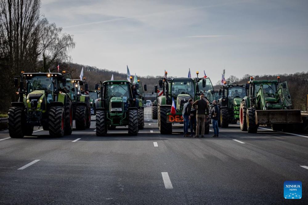 French farmers block a highway with their tractors during a protest in Longvilliers, near Paris, France, on Jan. 29, 2024. French farmers blocked motorways around Paris on Monday afternoon as they continued protesting against rising prices, red tape and "unfair competition" from other countries. (Photo by Aurelien Morissard/Xinhua)