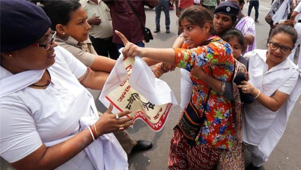 An activist scuffles with Indian police on Tuesday during a protest condemning a recent gang-rape in Kolkata
