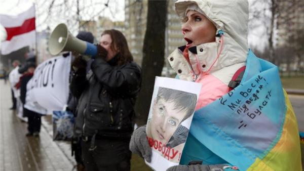 Belarusian protesters hold portraits of Savchenko during a gathering in her support