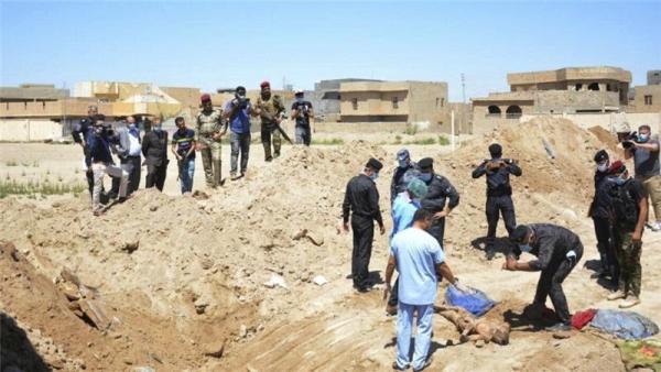 Iraqi security forces including a forensics team work at the site of a mass grave in the stadium area in Ramadi