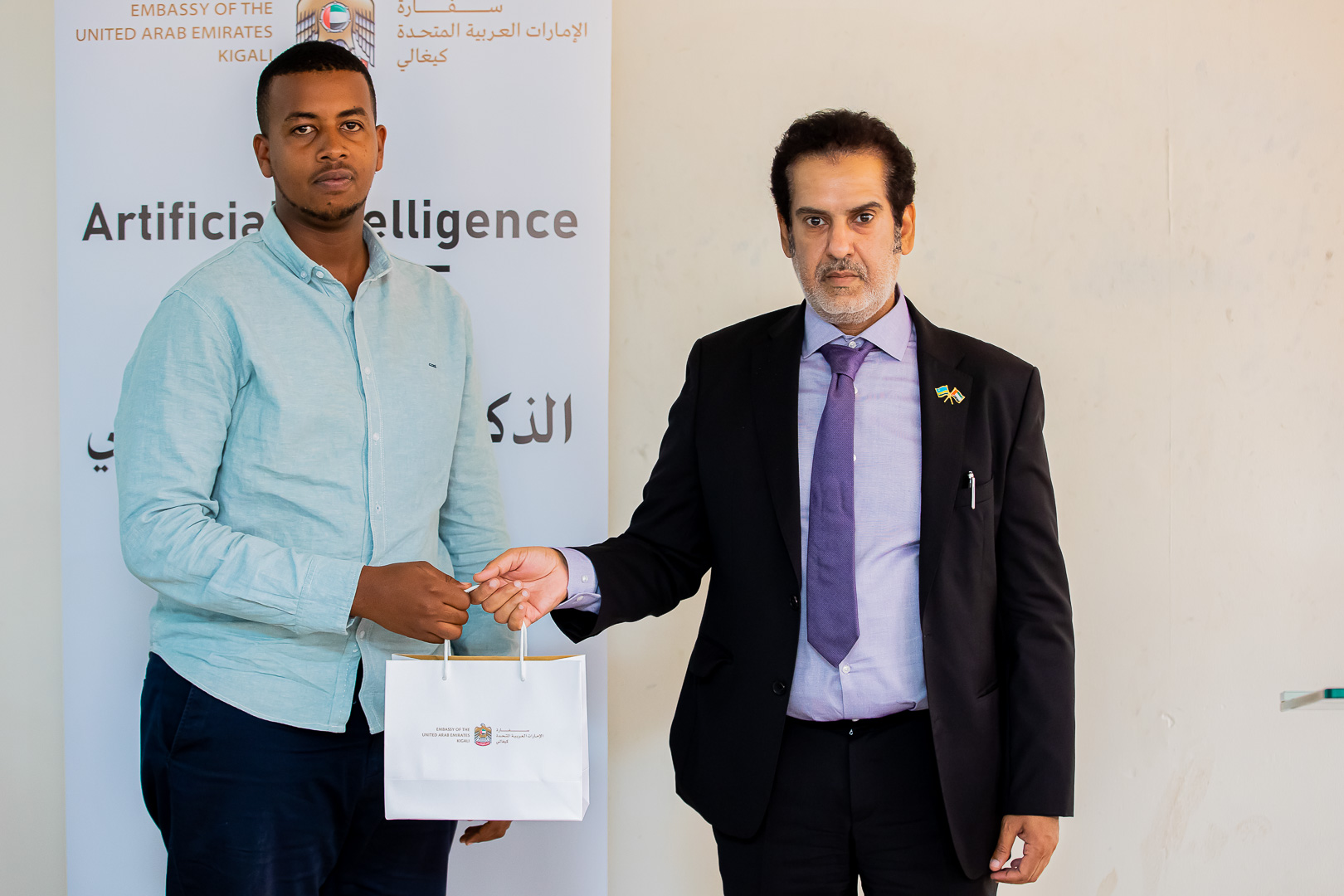 Amb. AlQahtani awarding one of four best performing students with smartphones.