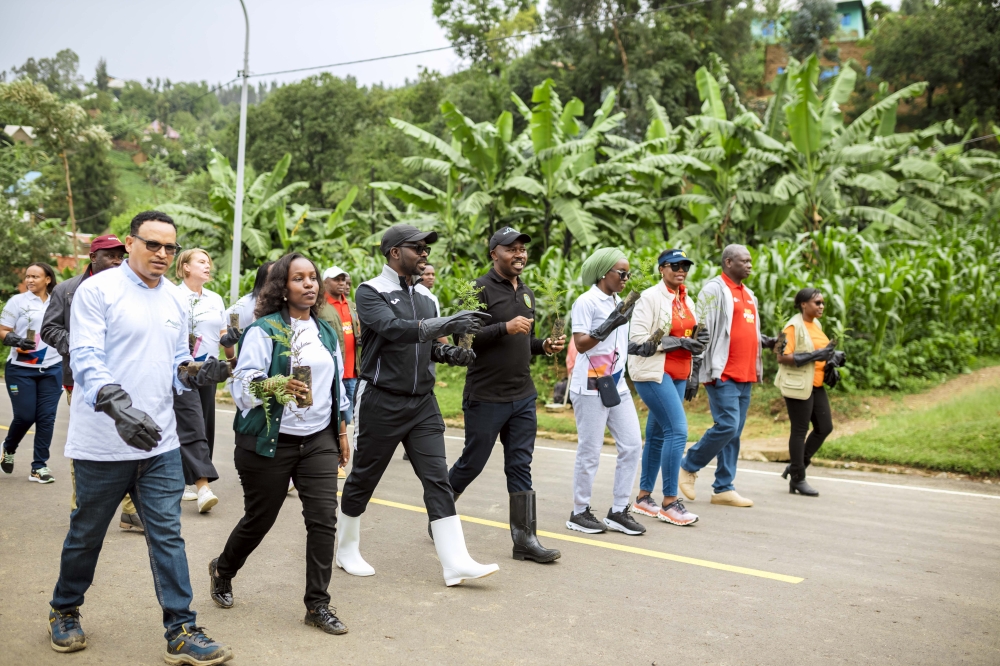 Minister of Trade & Industry, Mayor of Rubavu District, BRALIRWA Corporate Affairs Director, among other event participants carrying tree seedlings to plant during the community work.