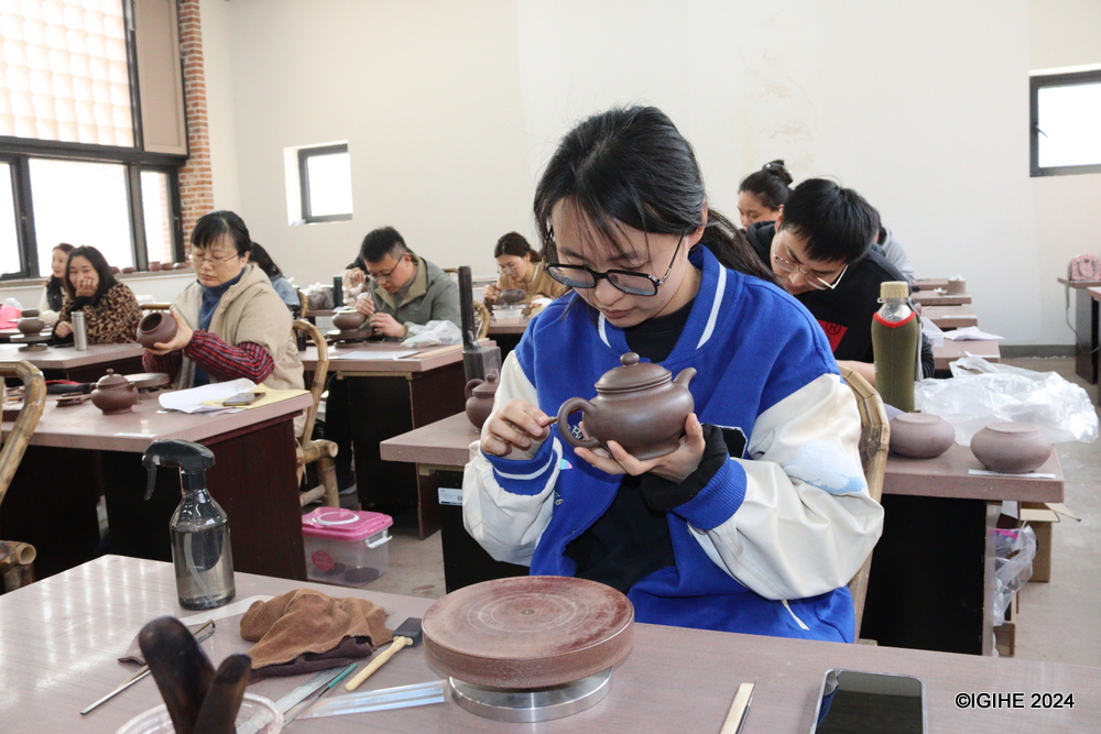 A student at the school making final touches on her clay pot.
