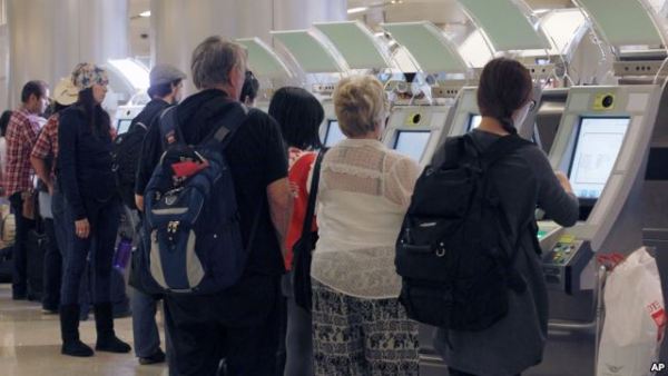 Passengers arriving from abroad at Los Angeles International Airport use new automated passport kiosks.