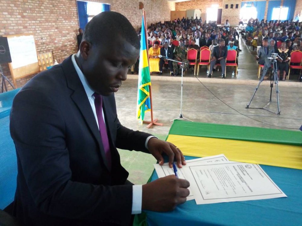 Uwamahor signs after taking the oath of the office