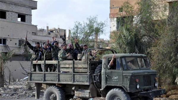 Forces loyal to Syria's President Bashar al-Assad flash victory signs in Palmyra after ISIL expulsion