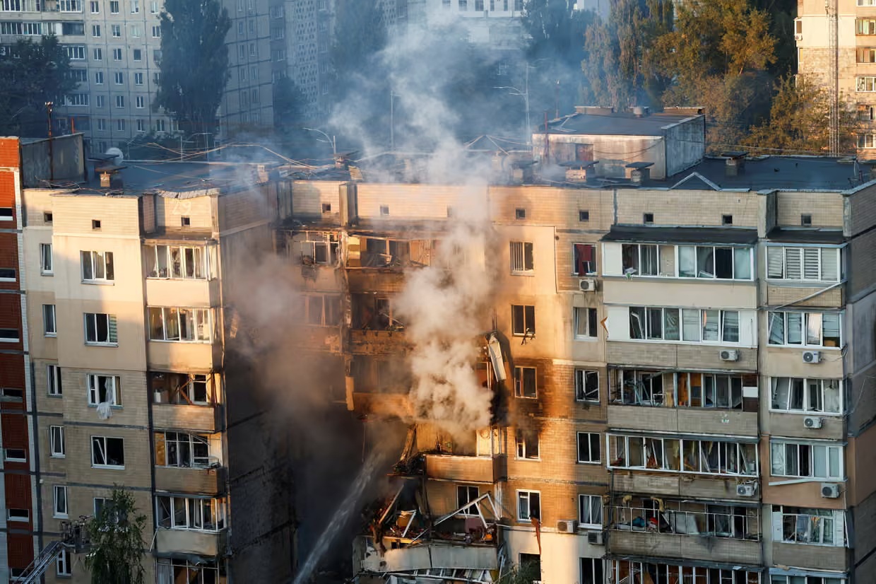 Emergency workers extinguish a fire in an apartment building on Sunday after Russia’s attack on Kyiv.