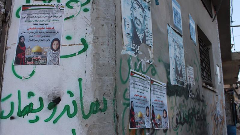 Newly attached posters on a a building wall in Qarawat Bani Zeid depict Fatima Hjeiji who was shot dead on May 7