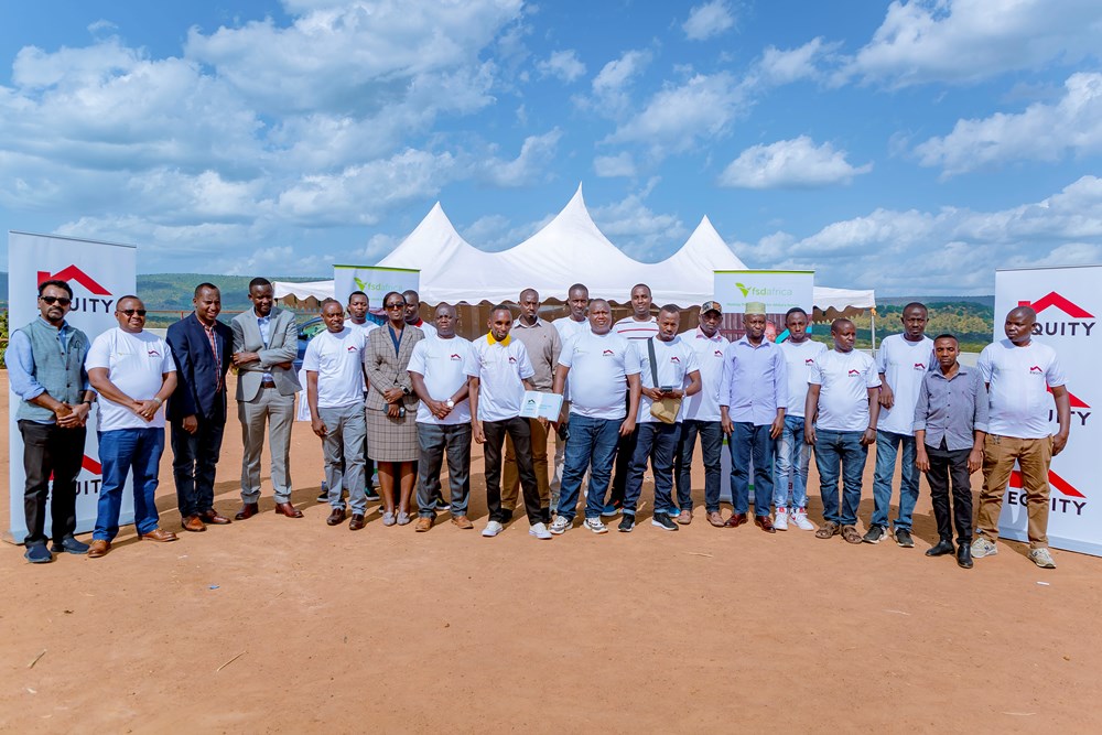 Officials pose for a photo with Equity Bank Agents operating in Mahama Camp.