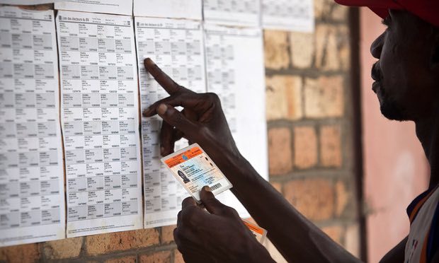 A man looks for his name on a list at a polling station in Kinshasa in 2011. DRC has said it does not have the money to hold an election this year.
